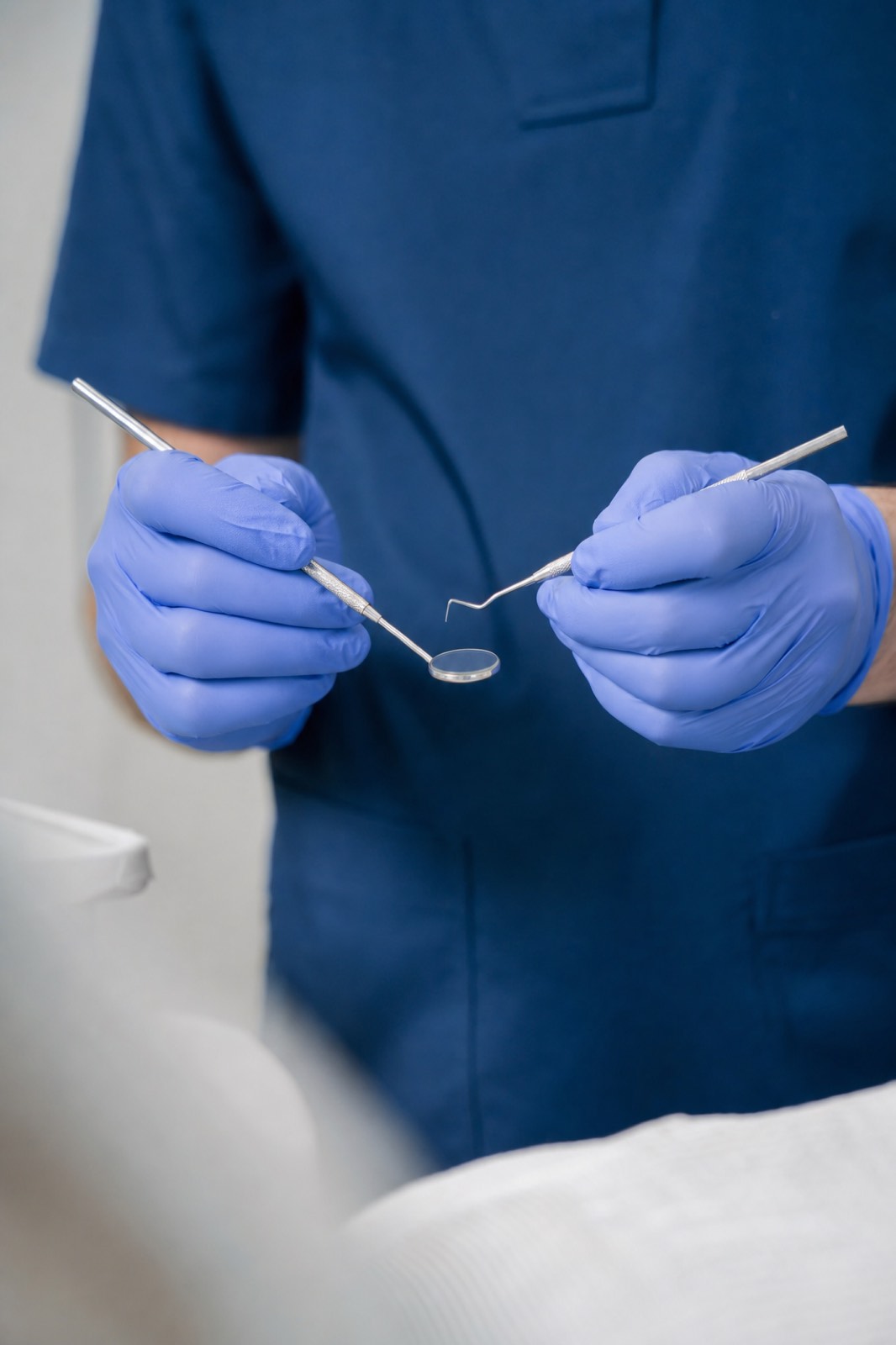 A dentist holding a mirror and probe before an examination
